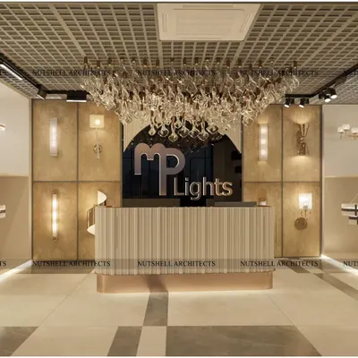 The reception area of the MP Lights showroom sets a tone of modern elegance. A stunning chandelier hangs over the bespoke desk, with various wall lights displayed on a textured backdrop, immediately immersing customers in the world of lighting.