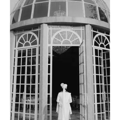 The groom's grand entrance into the wedding venue, a classic black and white shot filled with anticipation.