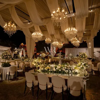 For this destination wedding, I created a dreamscape of draped ivory canopies and over 40 cascading chandeliers. The entire space glowed, with mirror-finish tables reflecting the light and the abundance of white roses and orchids.