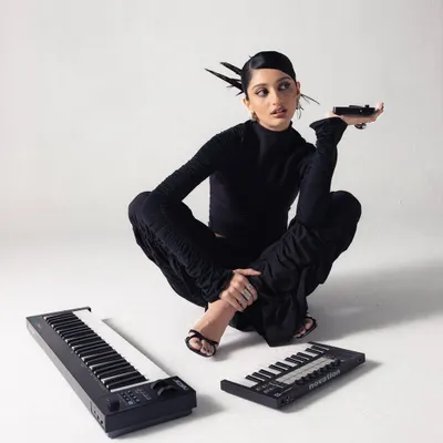 A stylized shot from a promo shoot for my debut track. I'm pictured with my portable MIDI keyboards, essential tools for sketching out melodies and basslines whether I'm in the studio or on the move.