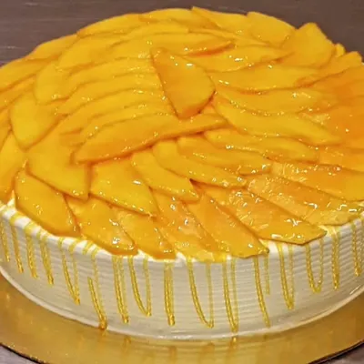 When mango season arrives, this is my go-to design. The cake is topped with a generous layer of freshly sliced Alphonso mangoes and finished with a light, sweet glaze and a simple drip effect around the sides.