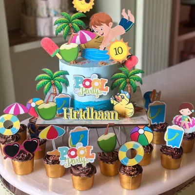 Pool party, but make it cake. This fun and vibrant pool party themed cake is surrounded by matching cupcakes, complete with tiny umbrellas, beach balls, and sunglasses. It's the perfect centerpiece for a summer birthday.