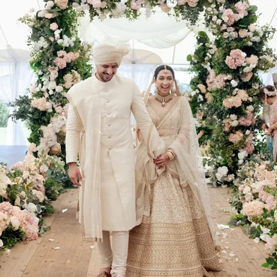 Manchal and Luca's joyful exit after their ceremony in the Australian countryside. The floral archway creates a perfect frame for this happy moment.