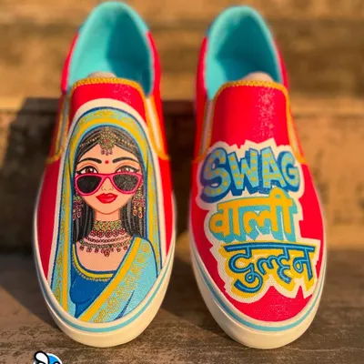 Custom kicks for a bride with swag. We hand-painted these bright pink slip-on sneakers with a cool bride illustration and the Hindi text "Swag Wali Dulhan" for a fun and unique wedding accessory.