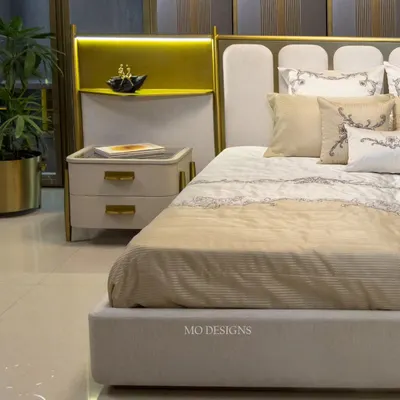 The Solitaire bed is designed to be the focal point of the bedroom. It features a unique headboard with elegant curves and integrated metal shelving with lighting, blending comfort and aesthetics while providing ample storage and style.