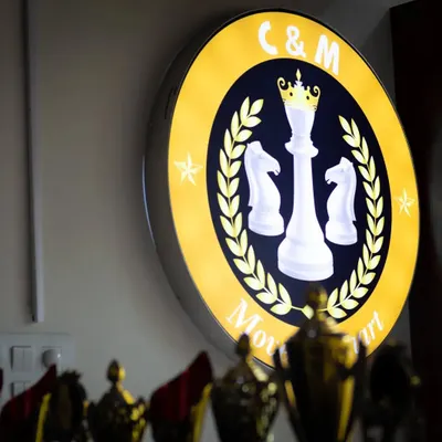 Our illuminated logo shines bright above the trophies won by our students. It's a symbol of our commitment to helping players "Move It Smart".