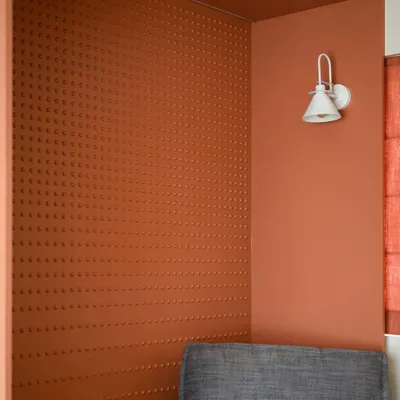 We designed this cozy reading nook in warm terracotta tones with intricate dotted accents on the wall. The snug lounger and stylish planters create a serene, contemporary, and sleek ambiance.