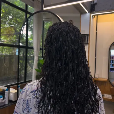 Here is the result of a hair perming service for long hair. The goal was to create uniform, defined, and bouncy curls that add significant volume and a completely new texture from root to tip.