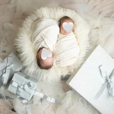 Twice the love, twice the joy. This newborn twin photoshoot features the babies swaddled peacefully together, surrounded by gift boxes to symbolize the precious gifts they are.