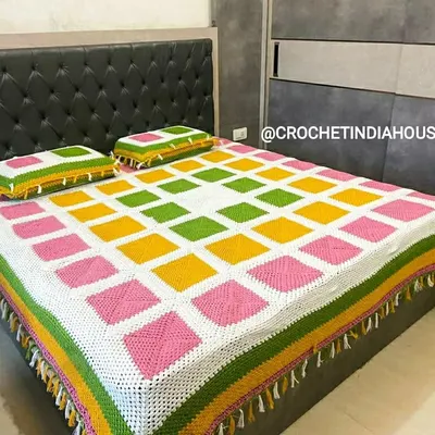 This complete handmade bed set, featuring a colorful granny square bedspread and two matching pillowcases, was a custom project. You can choose your own colors to create a unique look for your bedroom.