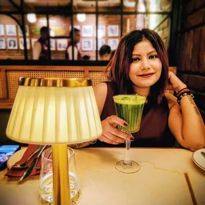 A quiet moment during a birthday dinner. This simple, sleeveless maroon dress is an elegant and timeless choice for a special evening celebration.