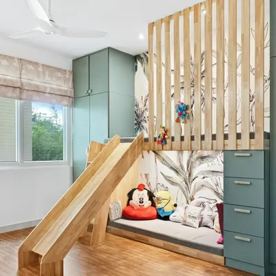 A dream kid's room with a loft bed that includes a fun wooden slide. The space is designed for play and imagination, with a cozy reading nook underneath and beautiful tropical wallpaper.