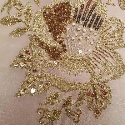 A close-up of my hand embroidery work, showing a floral motif created with shimmering sequins, delicate beads, and fine threadwork. These details are what make a custom outfit truly special.