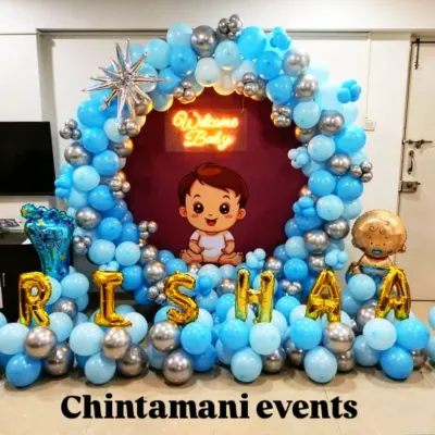 A grand 'Welcome Baby' decoration for a baby boy. The circular backdrop is filled with blue and silver balloons and features the baby's name in foil letters, creating a beautiful focal point for welcoming the newborn home.