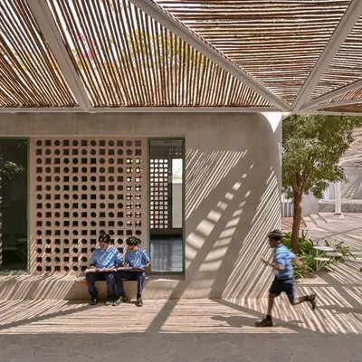 Shadow play at the Talaricheruvu Rural School. The bamboo canopy and perforated jaali walls create a constantly changing pattern of light, making the space dynamic and engaging for the children.