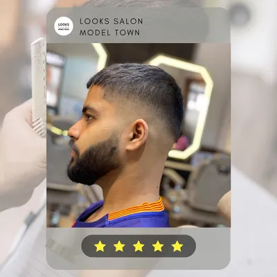 A perfect example of a modern men's haircut. This look features a sharp skin fade that blends seamlessly into a textured top, paired with a clean beard lineup.
