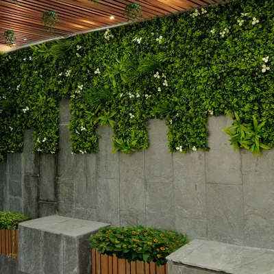 A vertical garden can completely change a space. Here, I used a combination of artificial greenery with small white flowers to cover a stone wall, creating a lush, maintenance-free feature that adds life and style under a slatted ceiling.