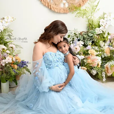A quiet moment between a mother and her daughter, both sharing in the excitement of the new baby to come. Twinning in these beautiful blue gowns makes the portrait even more special.