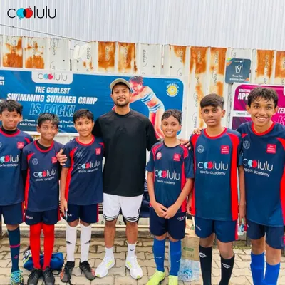A football team photo with their coach. Our coaches are mentors who guide, support, and inspire our players to be their best on and off the field.