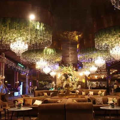 A wide view of a magnificent event hall I catered. The combination of grand floral chandeliers and plush lounge seating creates an opulent and inviting atmosphere for a memorable celebration.