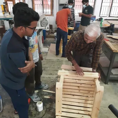 Our chief trainer works closely with diploma students, guiding them through the assembly of a slatted chair. This direct mentorship is key to helping students overcome challenges and refine their techniques.