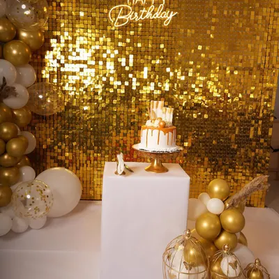 Here's a popular glam birthday setup featuring a gold shimmer wall that really catches the light. I paired it with a custom 'Happy Birthday' neon sign and a white and gold balloon garland for a complete party look.