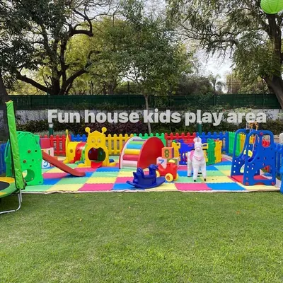 Our full-size rainbow play area set up on a lush green lawn. This arrangement includes a caterpillar tunnel, slide, rockers, a plush unicorn, and a trampoline, creating an all-in-one activity center.