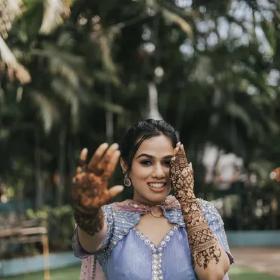 A playful and happy bride at her Mehendi. The makeup is fresh and fun, with a pop of color on the eyes to match her vibrant Papa Don't Preach outfit.