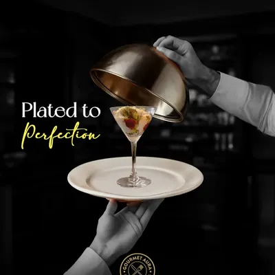 "Plated to Perfection." A server unveils a stunning dish in a martini glass, a symbolic representation of our commitment to elegant presentation and service.