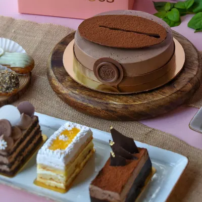 Our new menu is all set to woo you. Here's a glimpse of our coffee entremet cake alongside a selection of delicate pastries.