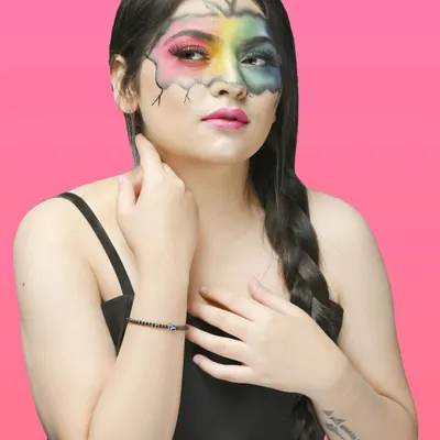 A portrait showcasing creative, artistic makeup with a rainbow and cracked-earth effect, perfect for a makeup artist's portfolio or a conceptual shoot.