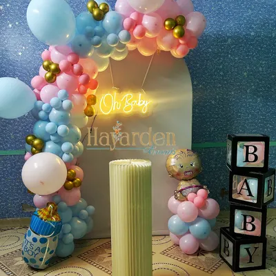 A lovely 'Oh Baby' gender reveal or baby shower setup. The pink and blue balloon arch, 'BABY' blocks, and themed foil balloons create a sweet and celebratory atmosphere.