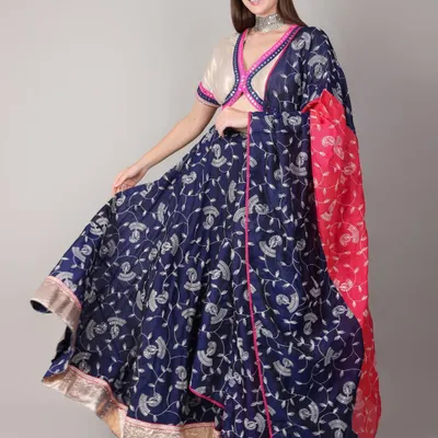 A model showcases the full twirl of this royal blue and pink Navratri lehenga. The lightweight fabric and comfortable fit are perfect for long nights of dancing Garba and Dandiya.