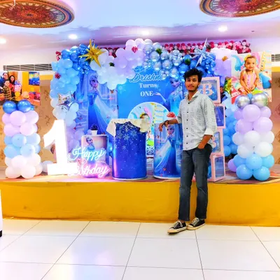 This is me, the person behind Blessing Balloons Decoration, standing proudly next to a Frozen-themed setup. I personally oversee the decorations to ensure everything is perfect for your special day.