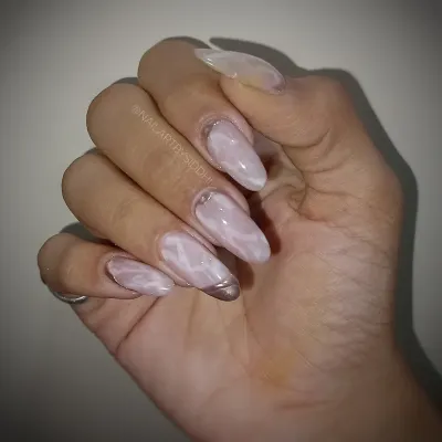 A beautiful example of a soft pink cat-eye effect, creating a marble-like shimmer on long almond nails.