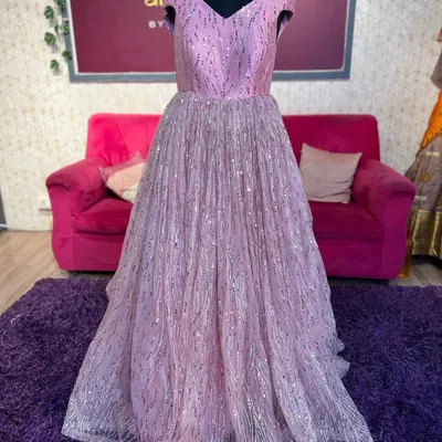 A full view of a beautiful lilac-pink sequin gown on a mannequin. This off-shoulder ball gown is perfect for receptions and evening parties.