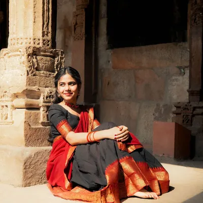 A candid moment of reflection during our Qutub Minar photoshoot. The warm sunlight hitting the ancient stone pillars created a beautiful, soft light for this natural portrait in a saree.