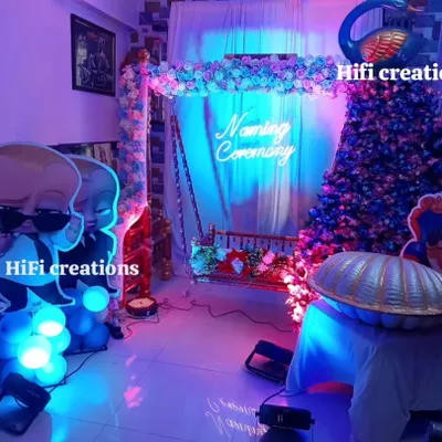 A fun 'Boss Baby' theme for a naming ceremony. This setup includes character cutouts, a decorated floral swing, and a custom 'Naming Ceremony' neon sign, all brought together with dramatic blue and purple lighting.