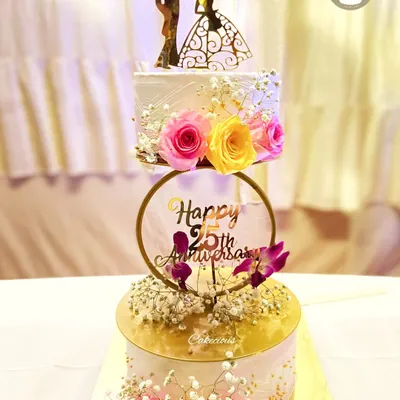 A beautiful two-tier cake to celebrate a 25th wedding anniversary. The design features a cascade of fresh flowers, combining elegance and romance for this silver jubilee.