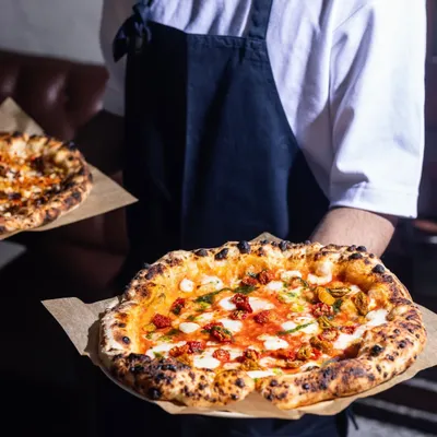 Double the pizzas, double the love. I’m here to make all your wood-fired cravings come true, serving up fresh pies that bring everyone to the table.