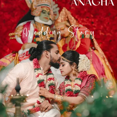 A beautiful moment from a Kerala wedding story, with the couple framed by Kathakali performers and vibrant red decor.