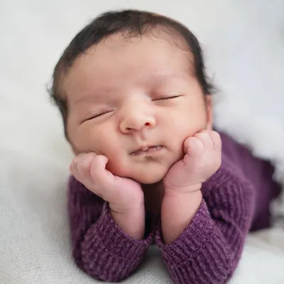 The perfect newborn pose, with tiny hands gently framing a peaceful, sleeping face. I patiently work to capture these serene moments, highlighting the pure innocence of your baby's first days.