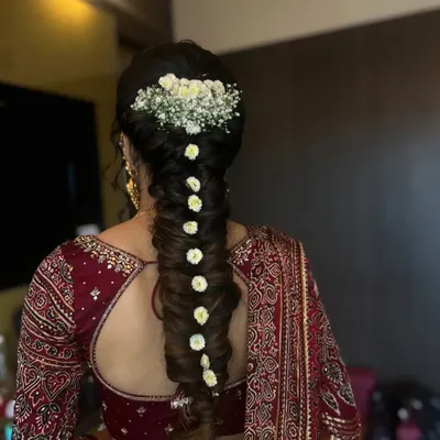 An elegant twisted braid for a Bhaat function, adorned with baby's breath and small white flowers. This style is both traditional and incredibly chic.