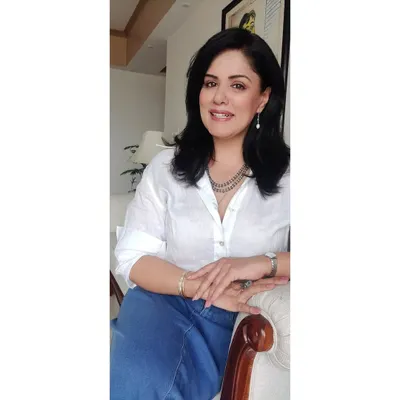 A close-up of my classic white linen shirt and denim skirt look. It’s a timeless pairing that I’ve elevated with a simple silver necklace and pearl earrings.