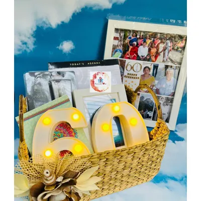 A milestone 60th birthday basket filled with personalized memories. This hamper features a large photo collage frame and light-up LED numbers.