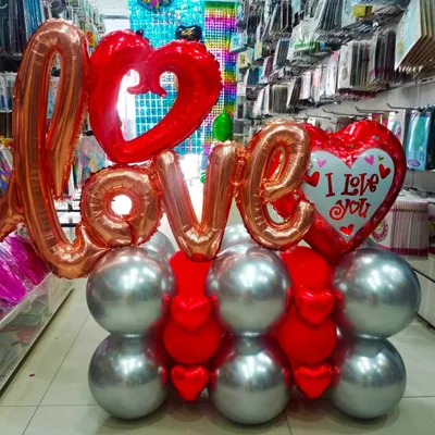 Say it loud and clear with this 'LOVE' balloon bouquet. This arrangement combines rose gold letter foils with red heart foils, all sitting on a sturdy base of red and silver balloons, making it a perfect gift.
