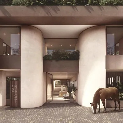 The entrance to "The Nest" is designed to be a welcoming threshold. The soft, curved fins of the facade create a gentle, nested feeling, drawing people into the lobby and shared spaces within this mixed-use urban building in Panjim.