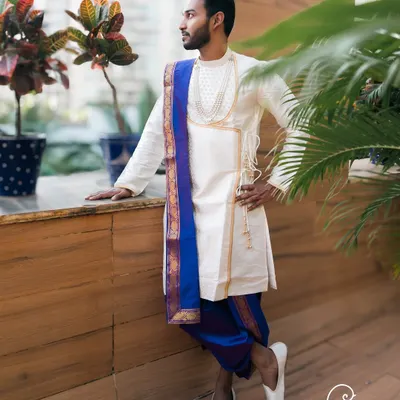 A stylish portrait of the groom in his traditional Maharashtrian attire, looking confidently into the distance.