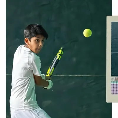 Every rally is a lesson in focus and determination. Here, a young player at our tennis academy keeps his eye on the ball, ready for the return shot.