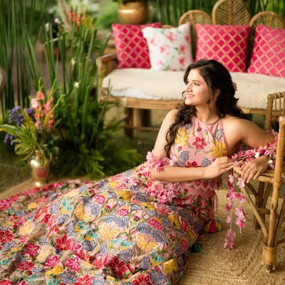 Yogita's Mehendi look was straight out of a fairytale. Surrounded by flowers, her fresh and radiant makeup with soft curls and a floral halter neck outfit created a truly dreamy and picturesque moment.